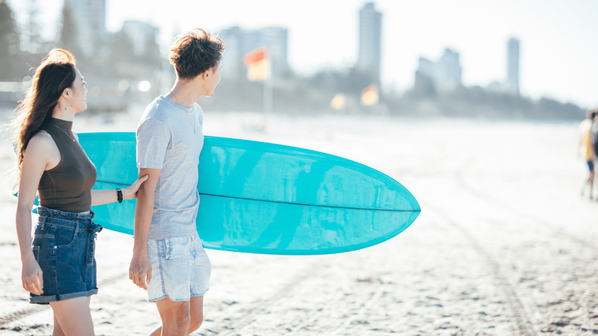 Couple-on-beach-with-surfboard