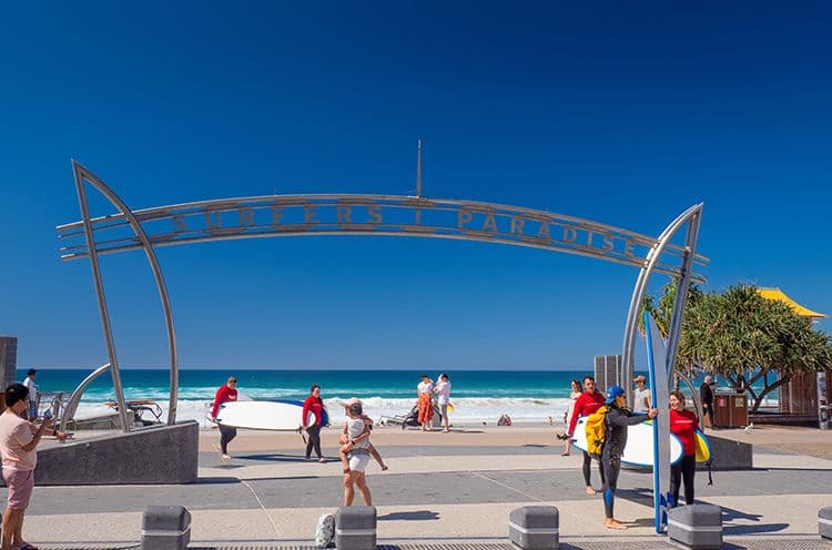 A Group Of People Walking On A Beach