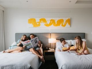 two couples in a bedroom, talking and laughing with each other